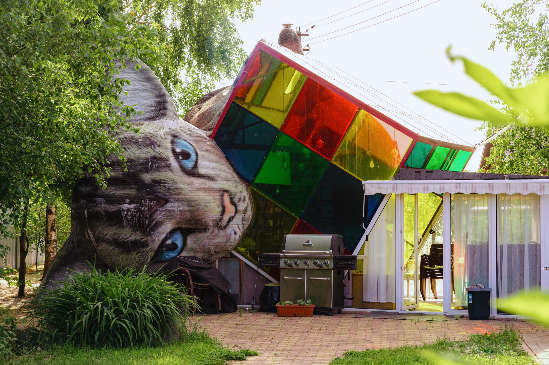 The Cat House — sculptural 3D-printed structure with a giant cat head and colored glass panels