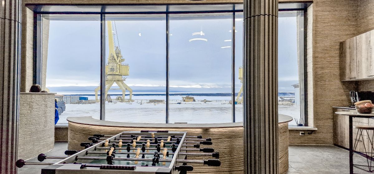 The Extreme Climate Capsule — 3D-printed interior lounge with a snowy arctic landscape outside