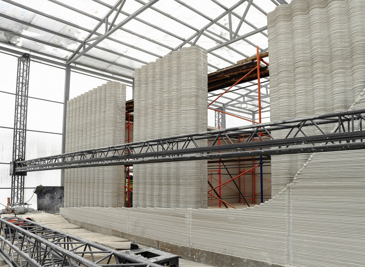 3D-printed concrete walls inside an enclosed construction bay