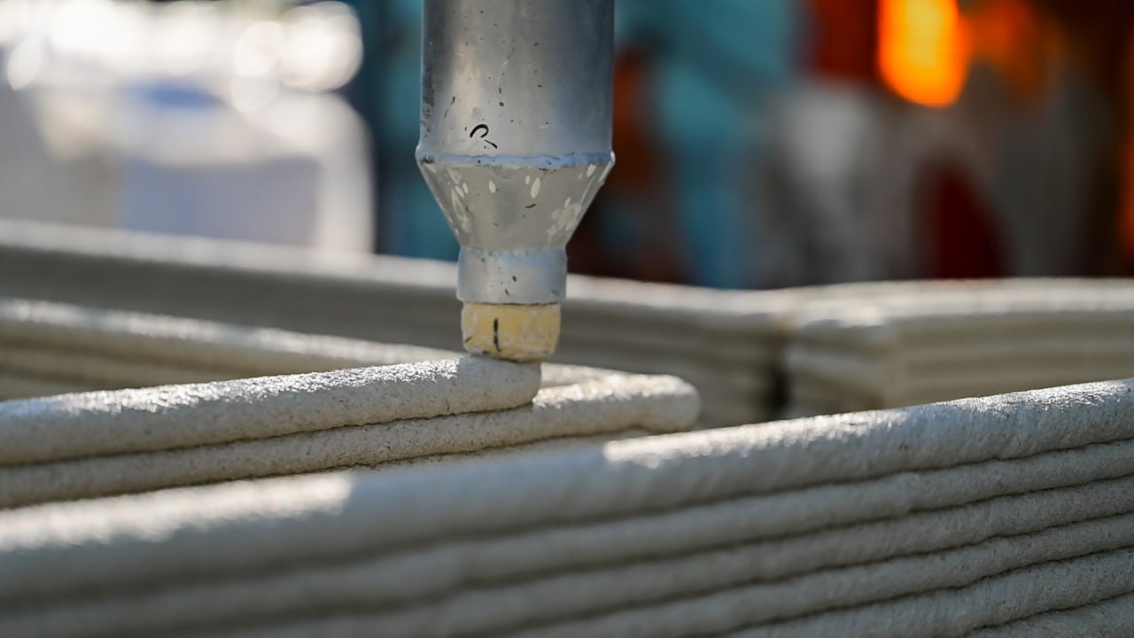 3D-printed concrete nozzle laying a fresh layer of material