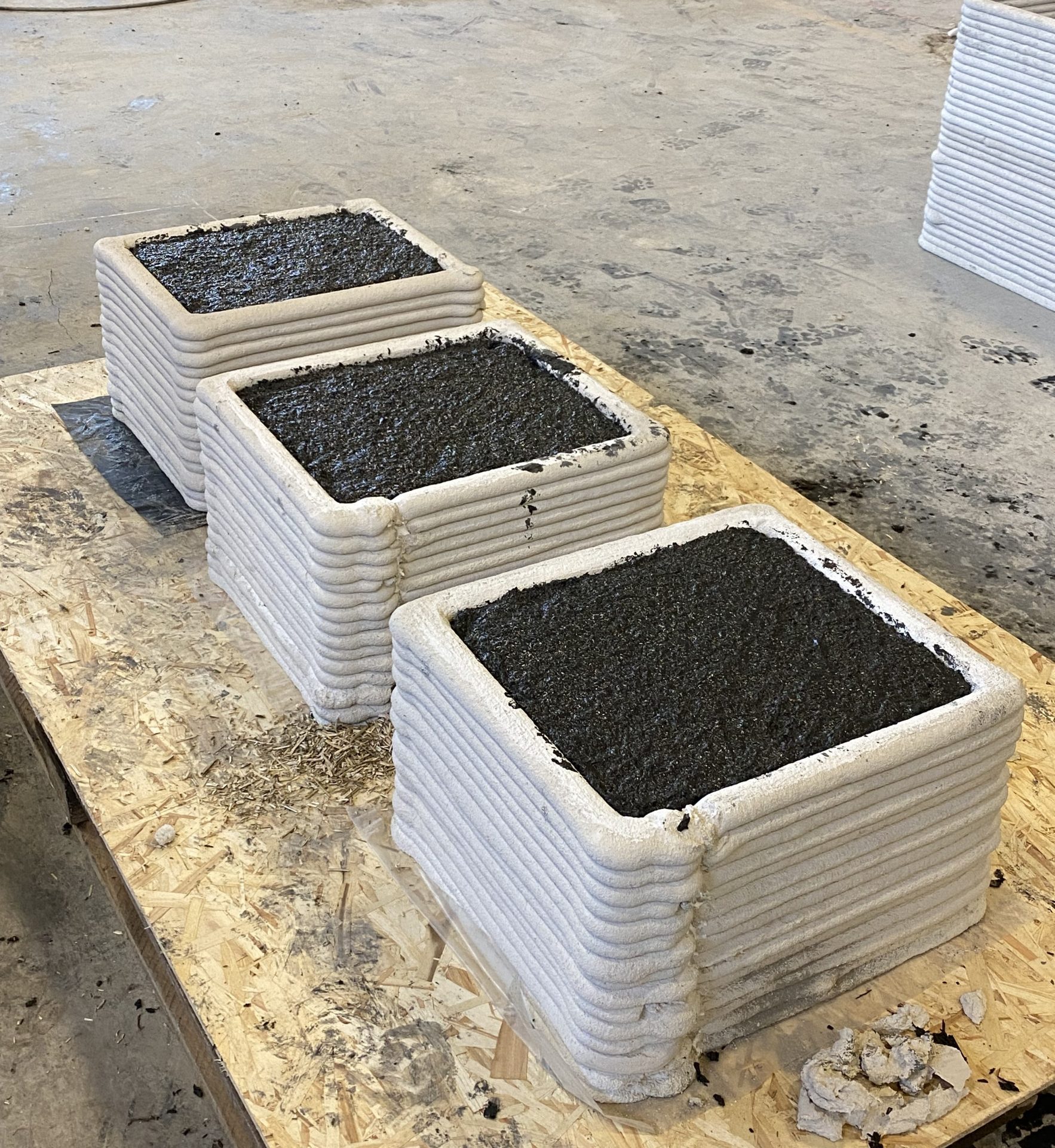 3D-printed concrete vessels filled with a custom dark aggregate mix